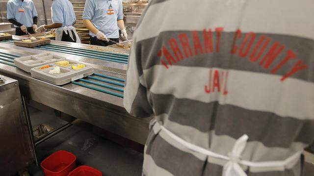 Five Star Correctional Services employees, in blue, prepare lunch trays as a Tarrant County Jail inmate stacks them for delivery at the Tarrant County Jail in downtown Fort Worth, Monday, November 23, 2015. Special/Brandon Wade